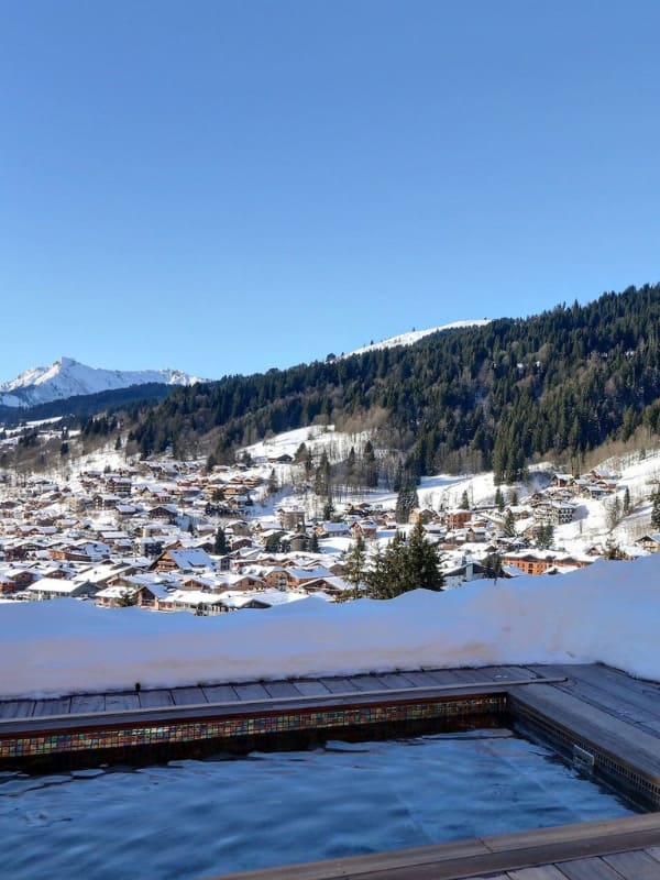 Vue depuis AVALON CHALET, chalet de luxe haute savoie, jacuzzi avec neige et vue sur la station. 